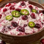 Costco Cranberry Jalapeno Dip spread on crackers and served as a party appetizer.