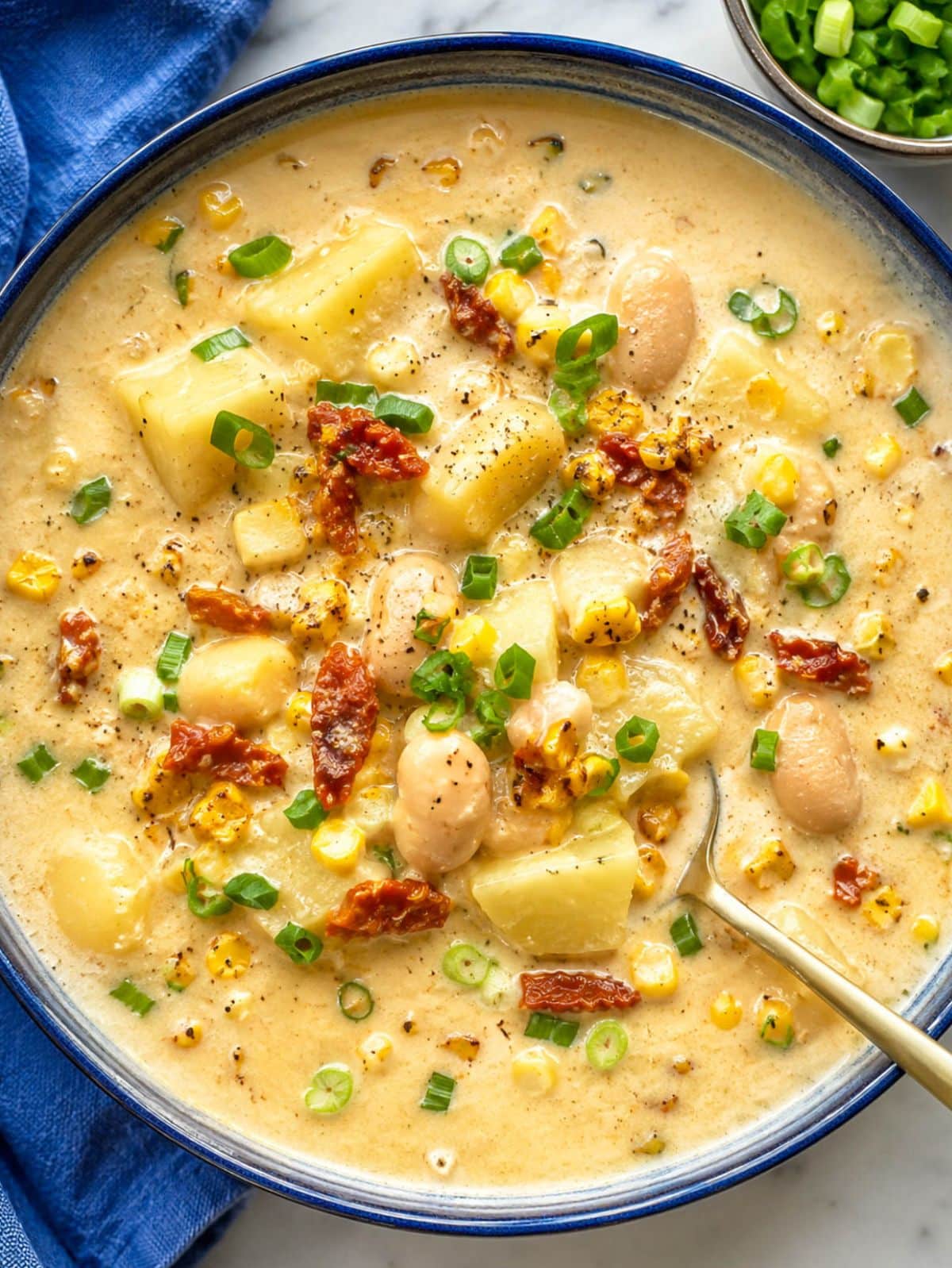Bowl of vegetarian corn chowder with butter beans, corn, and green onions.