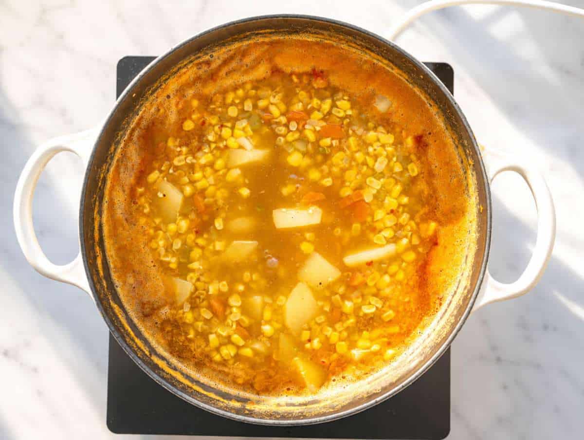 Step 3 Potatoes, butter beans, corn, and broth simmering in a large pot.